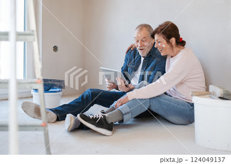 Senior couple renovating their home, browsing for inspirations on tablet. Senior couple renovating their home, browsing for inspirations on tablet. 124049137