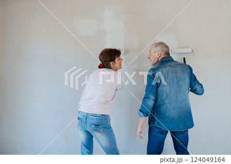 Senior husband and wife repainting the walls. Senior husband and wife repainting the walls. 124049164