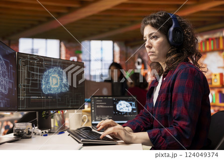 IT engineer wearing headphones works in AI tech agency providing custom software development services. IT expert listening music, using artificial intelligence technology to streamline coding process 124049374