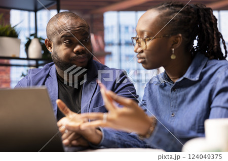 Happy couple making reservations for a family vacation on the laptop, entering bank credentials to approve a payment and booking a trip with hotel room. Confident people organizing travel plans. 124049375