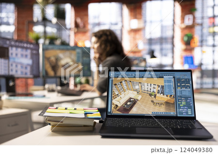 Woman uses architectural software on her PC to create a detailed 3D render of a home interior. The program allows to drag and configure furniture and other design elements for a virtual layout. 124049380