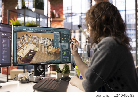 Home design professional uses architectural software to develop a floor plan, digital tool offers an intuitive interface for rendering apartment interiors with precise furniture placement. 124049385