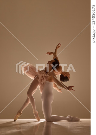 Graceful ballet duet moves in perfect harmony, man supporting woman as she leaning on him, capturing elegance, rhythm, and motion against soft warm light. Graceful ballet duet moves in perfect harmony, man supporting woman as she leaning on him, capturing elegance, rhythm, and motion against soft warm light. 124050178