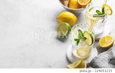 Two glasses of mojito cocktail with fresh lemon, lime, mint and ice on a light background Two glasses of mojito cocktail with fresh lemon, lime, mint and ice on a light background 124051215