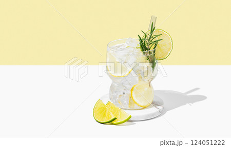 Cocktail mojito with lime, lemon, rosemary and ice in a glass on a white yellow background Cocktail mojito with lime, lemon, rosemary and ice in a glass on a white yellow background 124051222