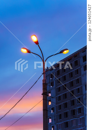 unfinished high-rise building against the backdrop of the sunset sky. building without finishing unfinished high-rise building against the backdrop of the sunset sky. building without finishing 124051427