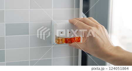 man plugging a plug-in air freshener 124051864
