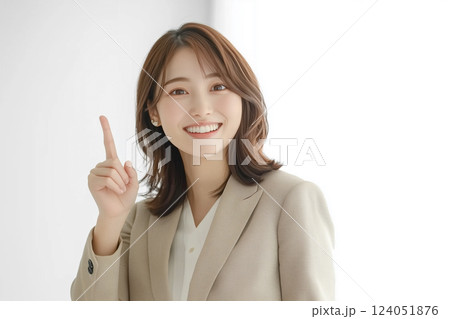 ビジネススーツ姿で笑顔で上方向に指差しする若い女性 124051876