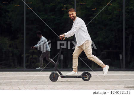 Riding the scooter. Stylish man is outdoors at daytime 124052135