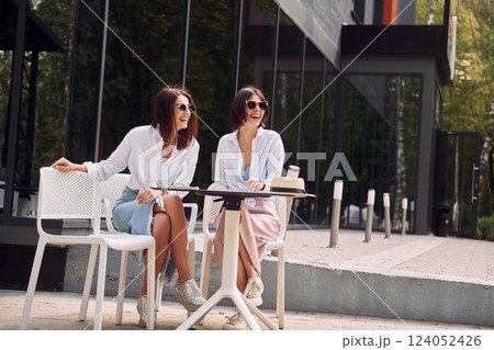 At sunny daytime. Two female friends have great weekend outdoors together At sunny daytime. Two female friends have great weekend outdoors together 124052426
