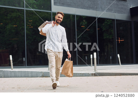 Shopping day. Stylish young man is outdoors with bags 124052880