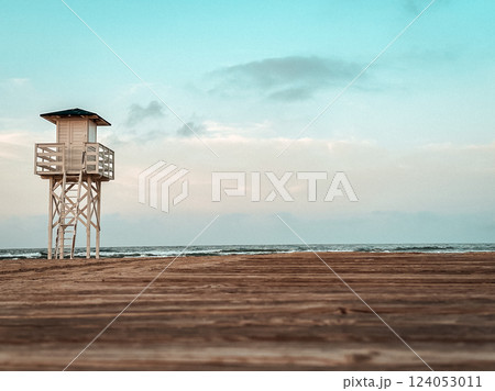 A white wooden lifeguard watchtower located on the beach. A rescue station on the ocean coast in the morning. Empty coastline. Summer holidays on sea A white wooden lifeguard watchtower located on the beach. A rescue station on the ocean coast in the morning. Empty coastline. Summer holidays on sea 124053011