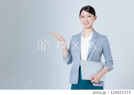 ノートパソコンを持って案内する女性ビジネスパーソン 124053373