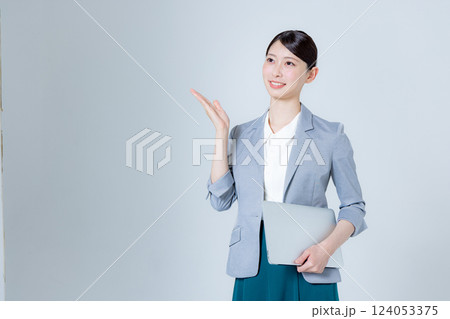 ノートパソコンを持って案内する女性ビジネスパーソン 124053375