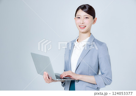 ノートパソコンを持って案内する女性ビジネスパーソン ノートパソコンを持って案内する女性ビジネスパーソン 124053377