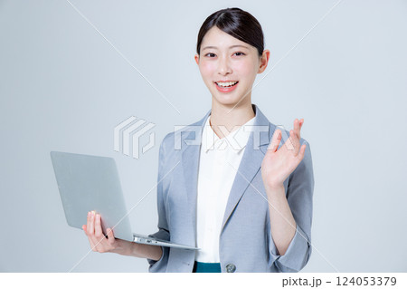 ノートパソコンを持って案内する女性ビジネスパーソン 124053379