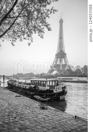 Dawn breaks over Paris as the Eiffel Tower stands tall, reflected in the calm Seine River. A boat is moored nearby, creating a tranquil atmosphere in the heart of the city. Dawn breaks over Paris as the Eiffel Tower stands tall, reflected in the calm Seine River. A boat is moored nearby, creating a tranquil atmosphere in the heart of the city. 124053568