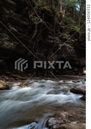 This image captures a fast-flowing river rushing over a rocky bed, creating whitewater rapids. This image captures a fast-flowing river rushing over a rocky bed, creating whitewater rapids. 124056553