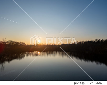 A Tranquil Sunset Casting Glows Over a Serene Lake, Perfectly Reflecting Natures Stunning Beauty 124056875