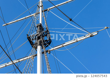 White ships mast, black platform, and rigged ropes are under blue sky White ships mast, black platform, and rigged ropes are under blue sky 124057543