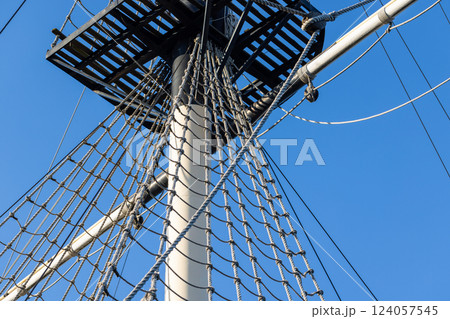 View of a ships mast, platform, and rigged ropes View of a ships mast, platform, and rigged ropes 124057545