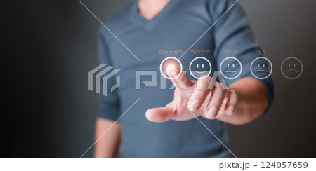 A man touches the icon on the happy smile face and gives five stars to indicate satisfaction with the service. Feedback, survey, and review concept. Rating: Very impressed. 124057659