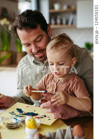 Father and little son decorating easter eggs at home. 124058181