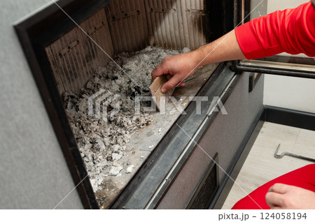 Cleaning the fireplace for cozy winter evenings and family gatherings in a modern home with a stylish design and warm ambiance 124058194