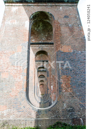 レンガ造りの歴史的な高架橋の楕円形の穴が開いた橋脚　ロンドンから南の郊外にあるオウズ渓谷にて 124058241