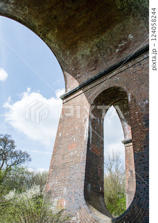 レンガ造りの歴史的な高架橋の楕円形の穴が開いた橋脚　ロンドンから南の郊外にあるオウズ渓谷にて 124058244