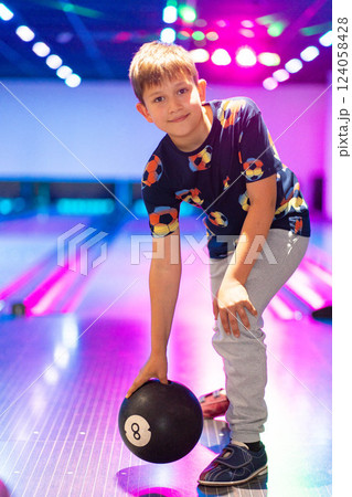 happy young boy child have fun cheering while playing bowling game bowling alley happy young boy child have fun cheering while playing bowling game bowling alley 124058428