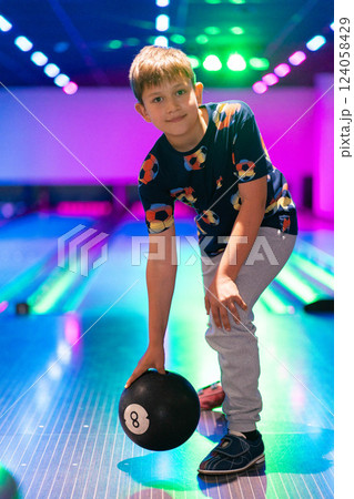 happy young boy child have fun cheering while playing bowling game bowling alley happy young boy child have fun cheering while playing bowling game bowling alley 124058429