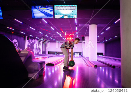 Young boy child having fun and playing bowling Young boy child having fun and playing bowling 124058451