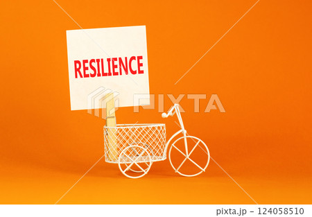 Resilience symbol. Concept word Resilience on beautiful white paper on clothespin. Beautiful orange background. Beautiful miniature white bicycle. Business resilience concept. Copy space. 124058510