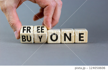 Buy and free one symbol. Businessman turns wooden cubes and changes words Buy one to Free one. Beautiful grey background, copy space. Business Buy and free one concept. Buy and free one symbol. Businessman turns wooden cubes and changes words Buy one to Free one. Beautiful grey background, copy space. Business Buy and free one concept. 124058606
