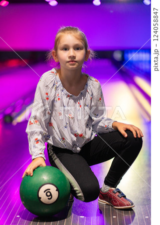 happy young girl having fun cheering while playing bowling game bowling alley 124058847