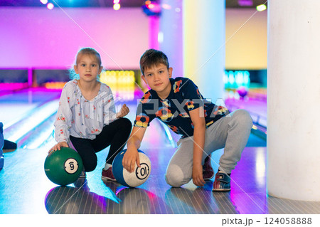 Two Young choldren girl boy siblings having fun and playing bowling 124058888