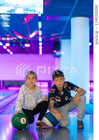 Two Young choldren girl boy siblings having fun and playing bowling 124058890