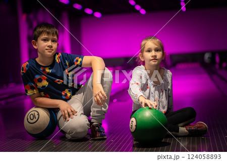Two Young choldren girl boy siblings having fun and playing bowling 124058893