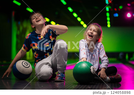 Two Young choldren girl boy siblings having fun and playing bowling 124058898