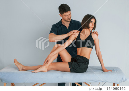 Grey colored background. Woman visiting physiologist that making massages and helping with traumas 124060162