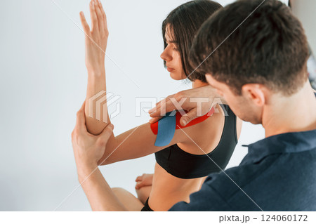 On the left hand. Woman visiting physiologist that putting kinesio tape on the skin 124060172