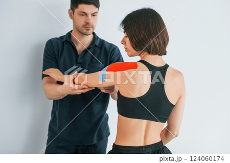 On the left hand. Woman visiting physiologist that putting kinesio tape on the skin 124060174