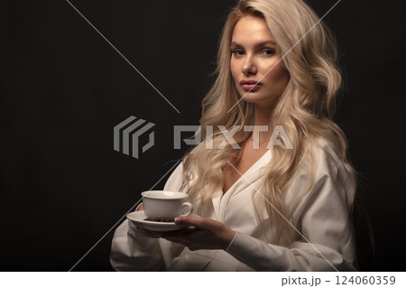 Studio photo portrait of a young pretty blonde on a dark background, close-up portrait of a woman 124060359