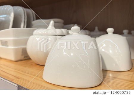 Elegant white ceramic containers on display in a cozy kitchen setting Elegant white ceramic containers on display in a cozy kitchen setting 124060753