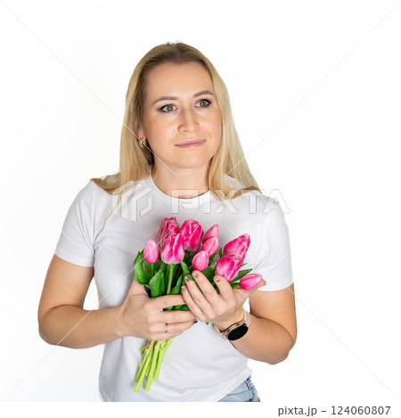 Beautiful blond mature european woman girl in white t-shirt is holding pink purple tulips isolated on white background Beautiful blond mature european woman girl in white t-shirt is holding pink purple tulips isolated on white background 124060807