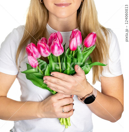 Beautiful blond mature european woman girl in white t-shirt is holding pink purple tulips isolated on white background Beautiful blond mature european woman girl in white t-shirt is holding pink purple tulips isolated on white background 124060813