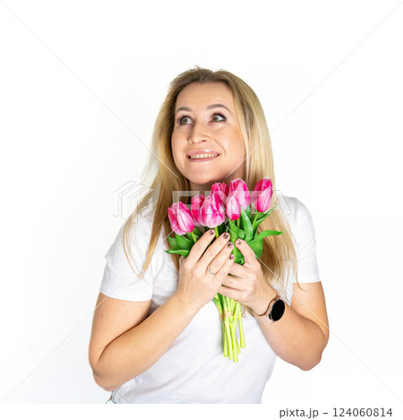 Beautiful blond mature european woman girl in white t-shirt is holding pink purple tulips isolated on white background 124060814