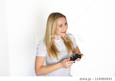 Photo of blond happy excited crazy smiling woman playing videogames addicted to playstation isolated on white background 124060841