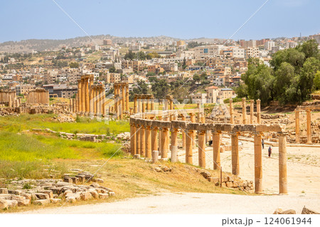 Ancient Roman forum ruins and pillars with modern arab city in the background, Jerash, Jordan 124061944